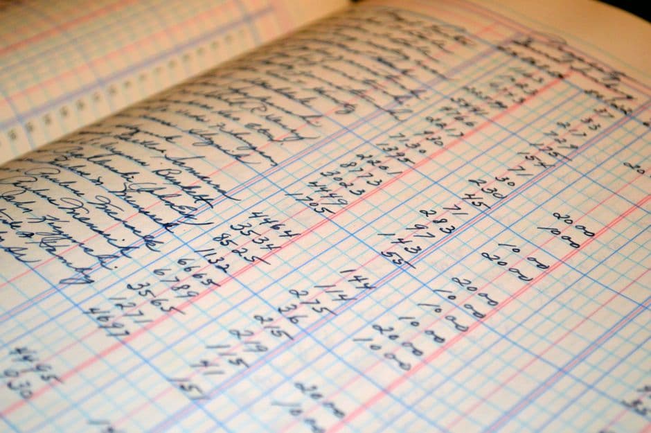 罫線で列が引かれた台帳に、手書きで金額が記入されているところ